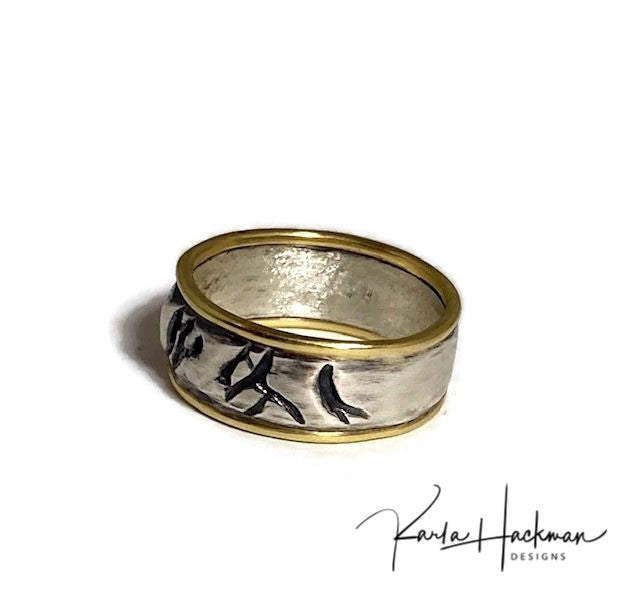 Hand carved in wax and cast in sterling silver, this hand-fabricated ring is edged in solid 18 karat gold on both sides. Ring is given an oxidized finish to highlight the abstract, natural organic texture.