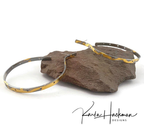 Sterling silver and detailed with 24K gold, these industrial hoop earrings are sure to stand out with their unique texture and pierced holes.