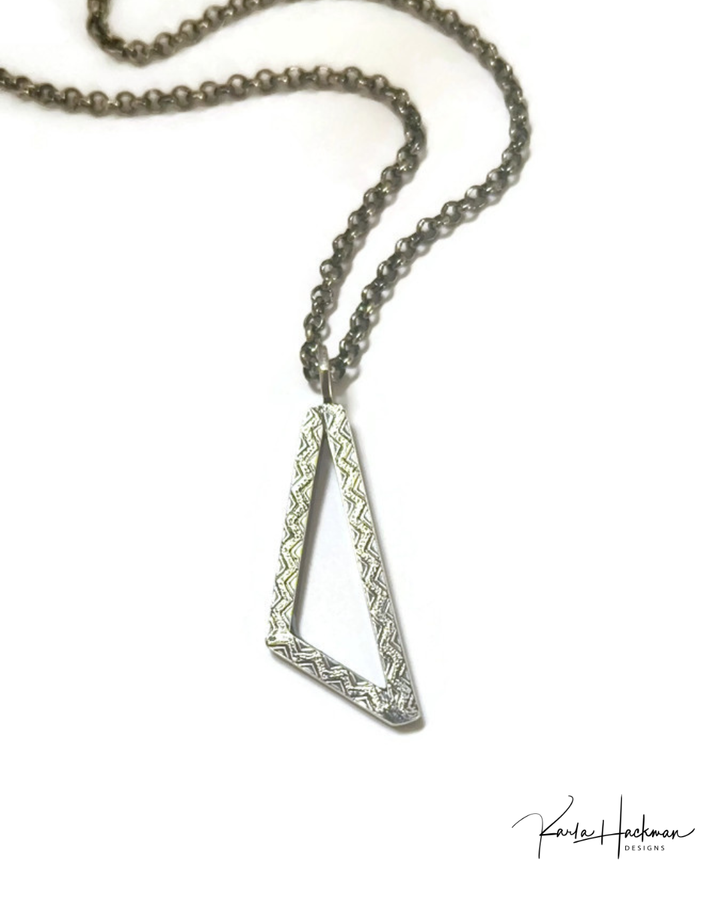 Silver necklace with a triangular pendant on a white background