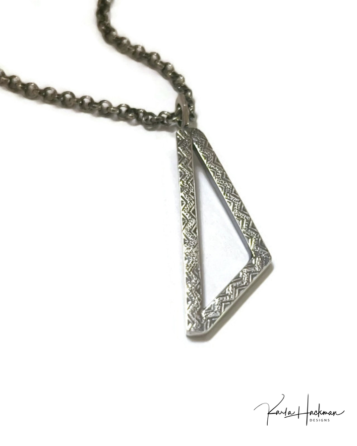 Silver geometric pendant necklace on a white background