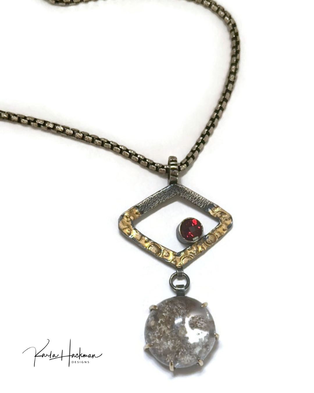 Necklace with a pendant featuring a red gemstone and clear stone with textured design on a white background.