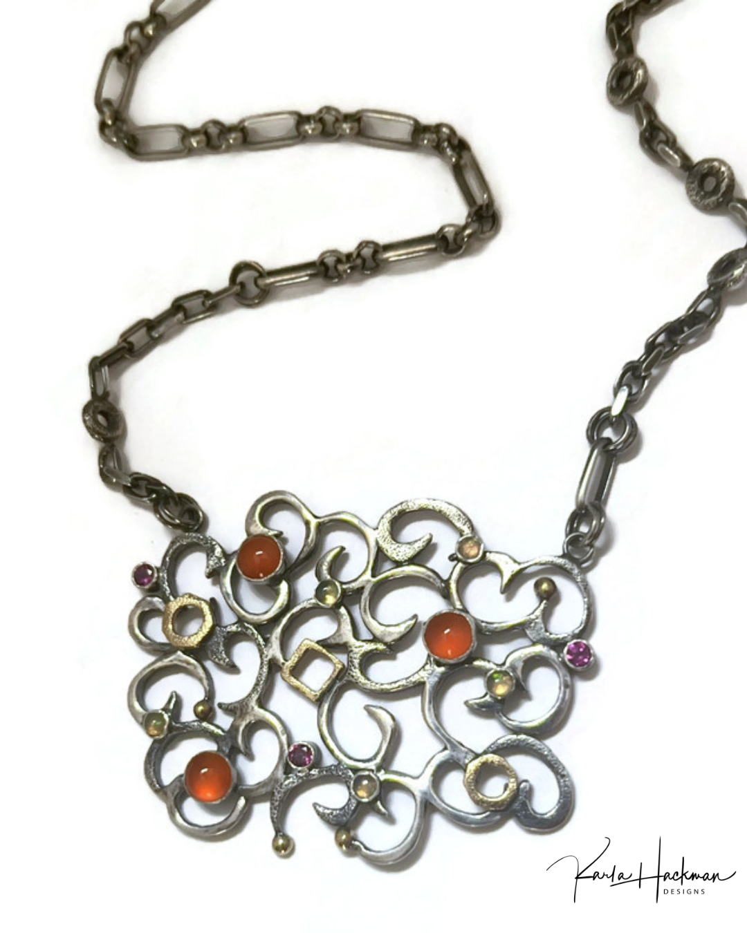 Ornate necklace with a detailed pendant featuring colored stones on a white background.