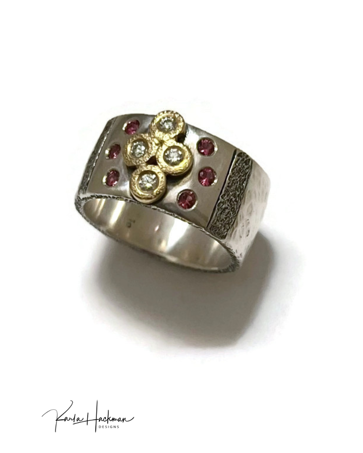 Silver ring with gold, diamonds, and pink gemstones on a white background