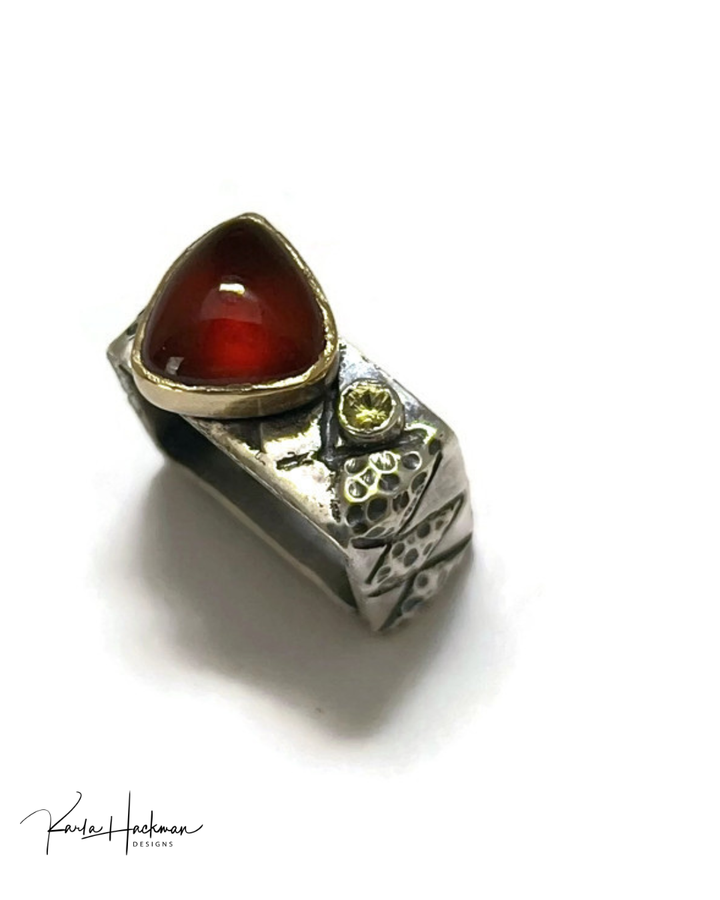 Silver ring with a red gemstone on a white background