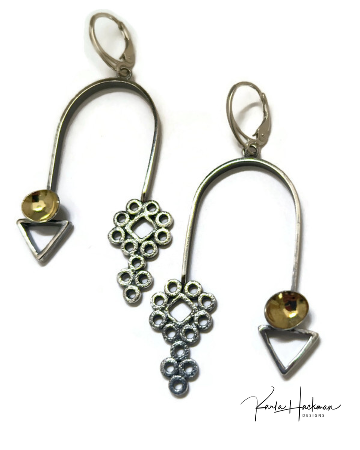 Pair of silver earrings with geometric designs on a white background
