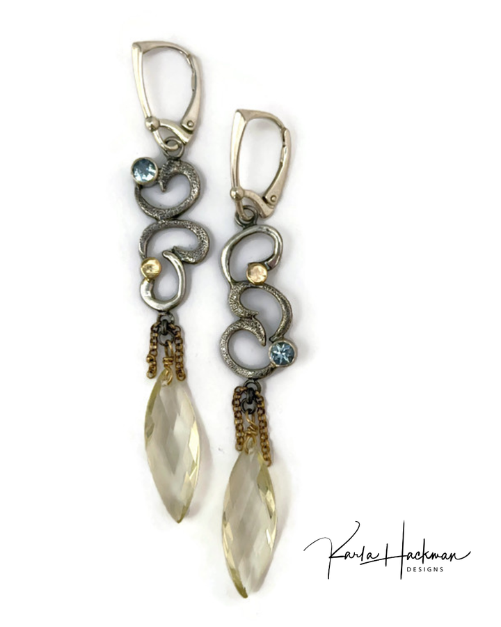 Pair of elegant gemstone earrings with intricate designs and gemstones on a white background.