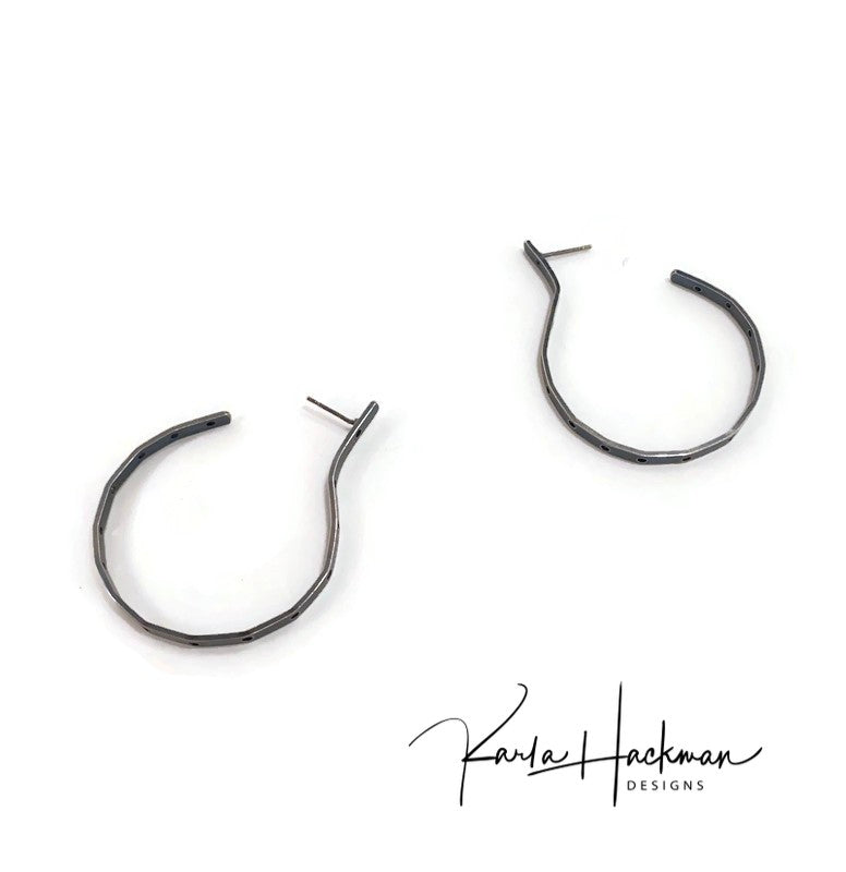 Hand-fabricated sterling silver hoops, with a post, are given a modern shape and pierced with over a dozen holes to create a contemporary, chic earring.