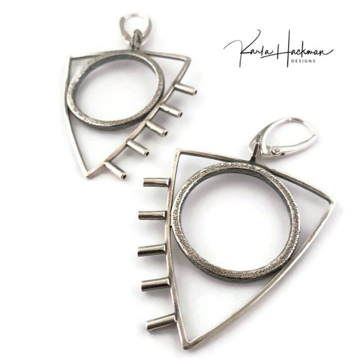 These earrings are a little rock and roll and a whole lot of fun! Large sterling silver, textured circles are surrounded by triangles and finished with tube accents. Earrings are lightly oxidized and finished with lever backs. Solid sterling silver.